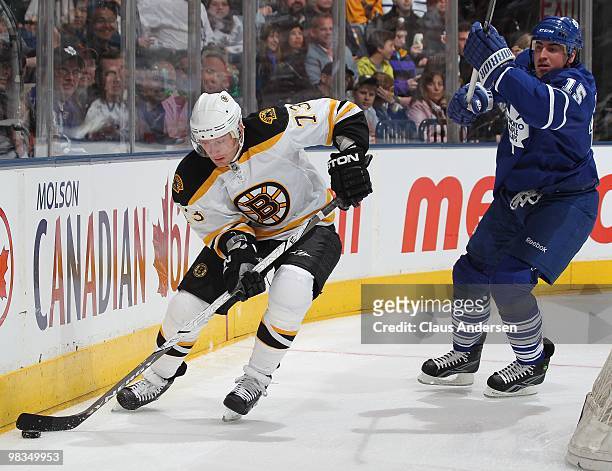 Michael Ryder of the Boston Bruins skates with the puck away from Tomas Kaberle of the Toronto Maple Leafs in a game on April 3, 2010 at the Air...