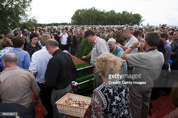 Mourners show show their respect by placing earth on the grave as they attend the funeral of Afrikaner Resistance Movement slain leader Eugene...