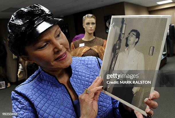 Maria Elena Holly who is the widow of rock legend Buddy Holly, holds a rare studio photo of him before an auction of the late singers memorabilia at...