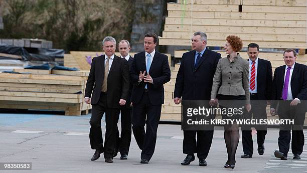 Conservative Party leader David Cameron, flanked by unidentified officials, arrives for a visit to a timber systems company in Aberdeen in Scotland,...
