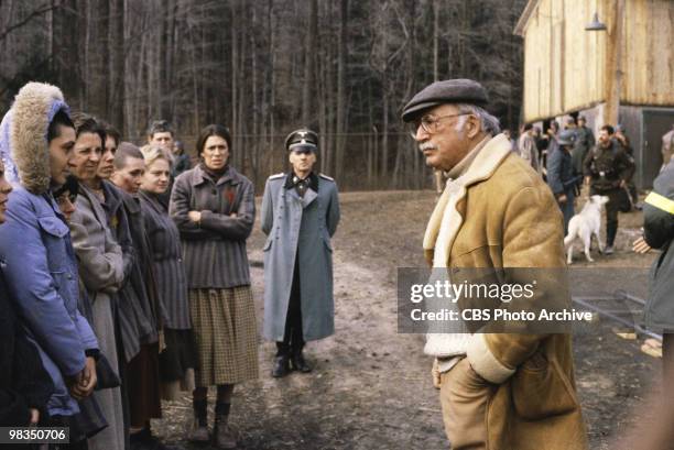 American film and television director Daniel Mann reviews a scene with various unidentified cast members on the set of the made-for-televsion film...