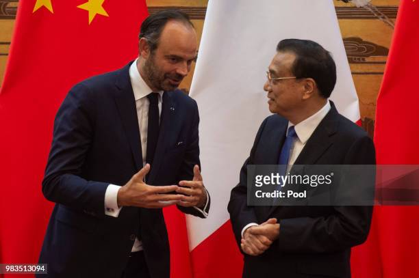 French Prime Minister Edouard Philippe speaks to China's Premier Li Keqiang during a signing ceremony at the Great Hall of the People on June 25,...