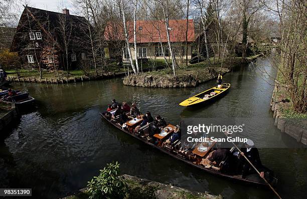 Man ferrying tourists in a pirogue encounters a pirogou delivering mail as he navigates the narrow canals of the Spreewald forest on April 9, 2010 in...