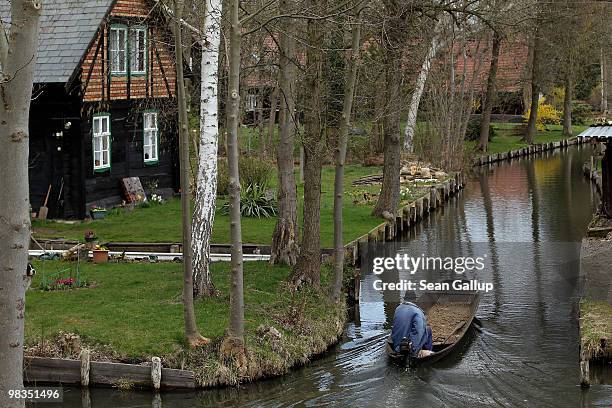 Local resident in a pirogue navigates the narrow canals of the Spreewald forest on April 9, 2010 in Luebbenau, Germany. The Spreewald is interlaced...