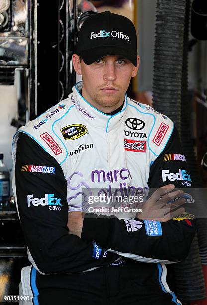 Denny Hamlin, driver of the FedEx Office/March of DimesToyota, looks on from the garage during practice for the NASCAR Sprint Cup Series Subway Fresh...