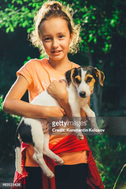 girl holding a dog smiling and looking at camera - 水平軸風力タービン ストックフォトと画像