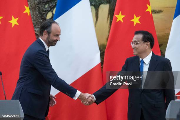 French Prime Minister Edouard Philippe shakes hands with China's Premier Li Keqiang as they attend a joint press conference at the Great Hall of the...