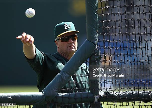 Manager Bob Geren of the Oakland Athletics pitches batting practice before the game between the Seattle Mariners and the Oakland Athletics on...