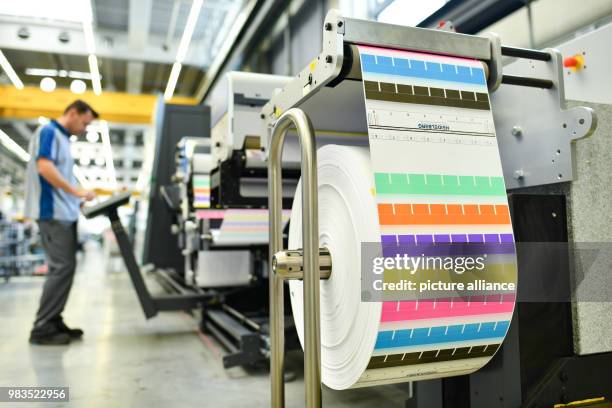 June 2018, Germany, Wiesloch: An employee standing at a digital label printing machine of the type "Gallus Labelfire" in the workshop of Heidelberger...