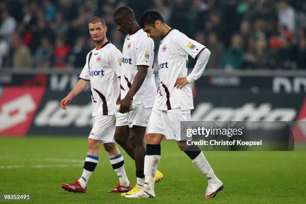 Marcel Heller, Juvhel Tsoumou and Caio of Frankfurt look dejected after losing 0:2 the Bundesliga match between Borussia Moenchengladbach and...