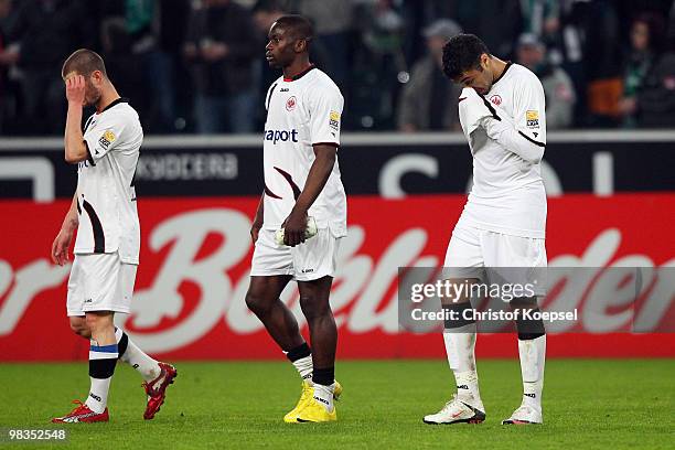 Marcel Heller, Juvhel Tsoumou and Caio of Frankfurt look dejected after losing 0:2 the Bundesliga match between Borussia Moenchengladbach and...