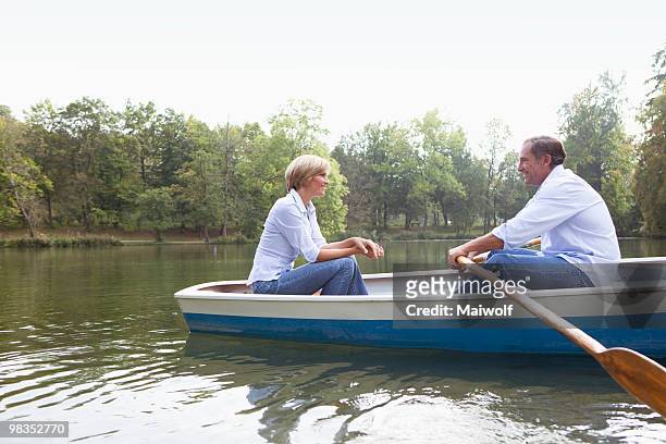 middle aged couple in a rowboat - 手漕ぎ船 ストックフォトと画像
