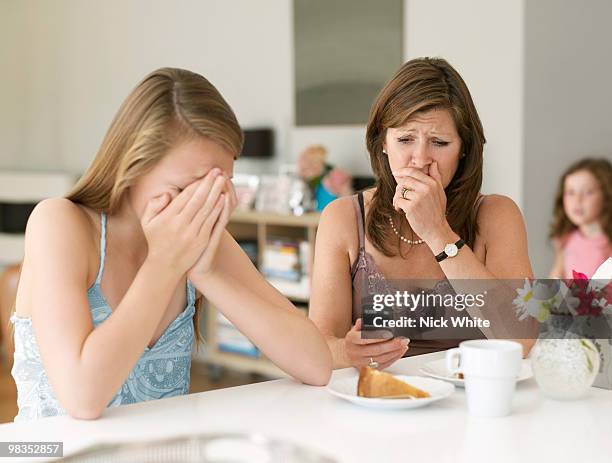 mother sees cyber bullying on cellphone - teenagers eating with mum stock pictures, royalty-free photos & images