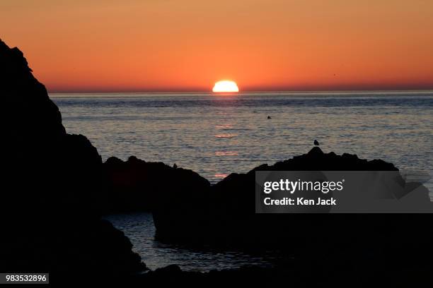 The sun rises over the North Sea, viewed from St Abb's harbour, on June 25 St Abb's, Scotland.