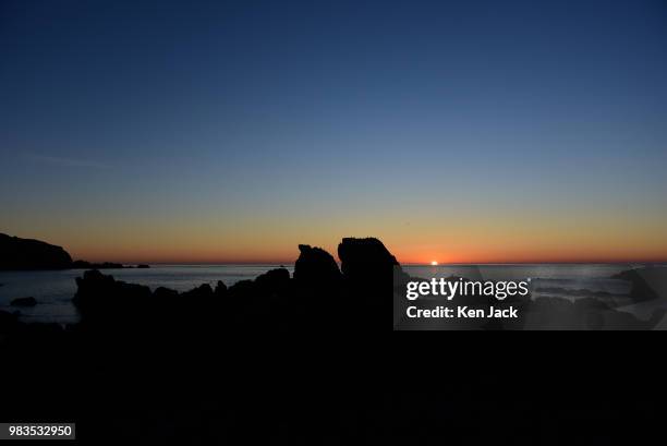 The sun rises over the North Sea, viewed from St Abb's harbour, on June 25 St Abb's, Scotland.