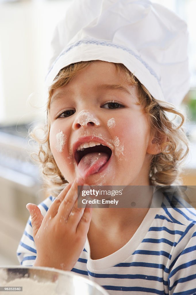 Young boy tasting dough