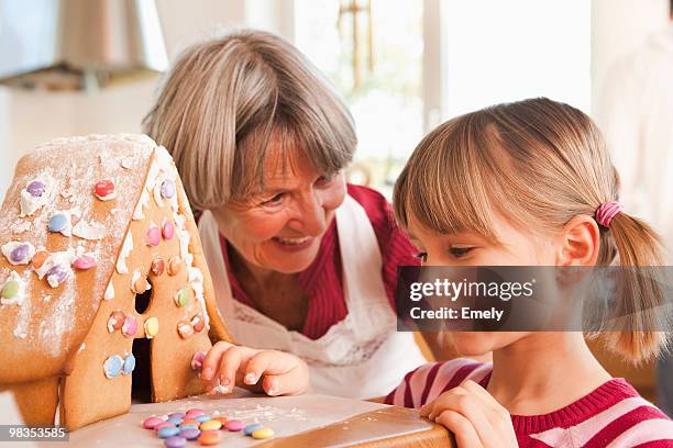 grandma and grandchild baking cake - woman back stock-fotos und bilder