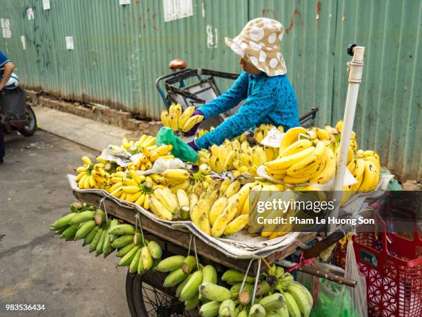 unidentified people sells the banana bunches on the rickshaw in saigon vietnam. - go bananas stockfoto's en -beelden