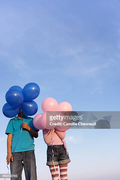 two children hidden behind balloons - chevreuil 個照片及圖片檔