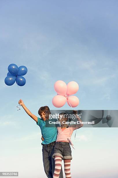 two children laughing with balloons - chevreuil 個照片及圖片檔