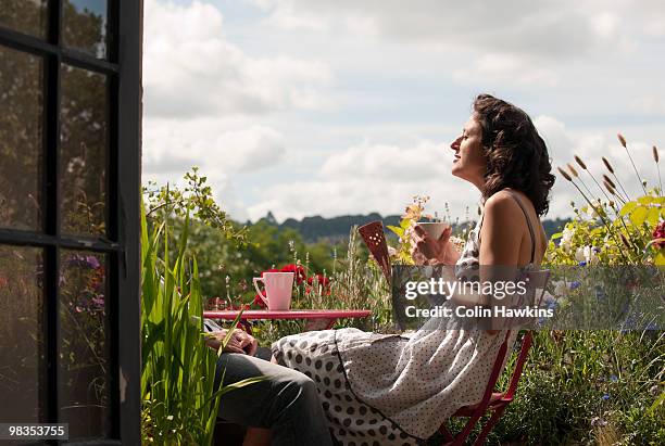 woman on balcony drinking tea - té terraza fotografías e imágenes de stock