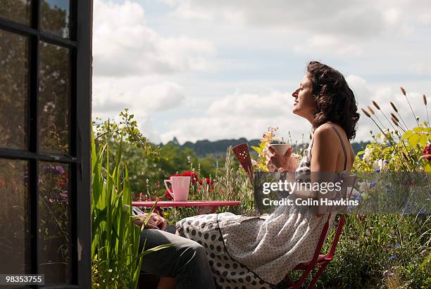 woman on balcony drinking tea - tea outdoor stock pictures, royalty-free photos & images