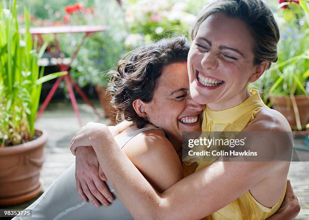 two women hugging on balcony - girlfriend stock pictures, royalty-free photos & images