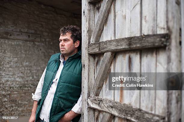 farmer standing in barn - concerned farmers stock-fotos und bilder