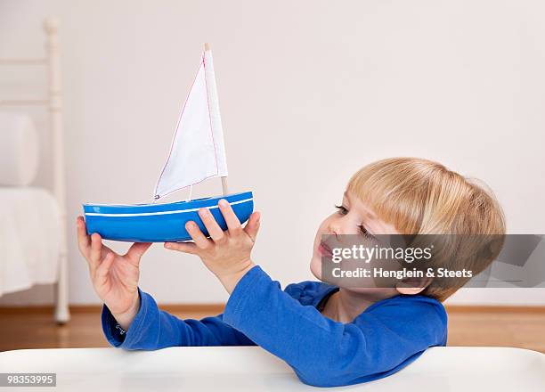 boy with toy boat - kid sailing stock-fotos und bilder