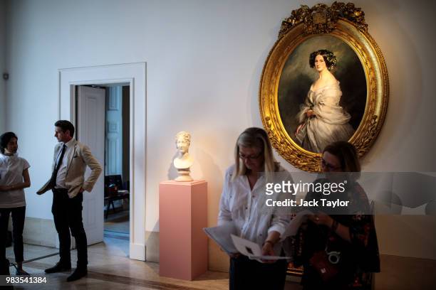 Gallery workers gather in front of a 'Bust of Caroline Murat nee Bonaparte' by Antonio Canova and 'A Portrait of A Lady, Therese Freifrau Von...