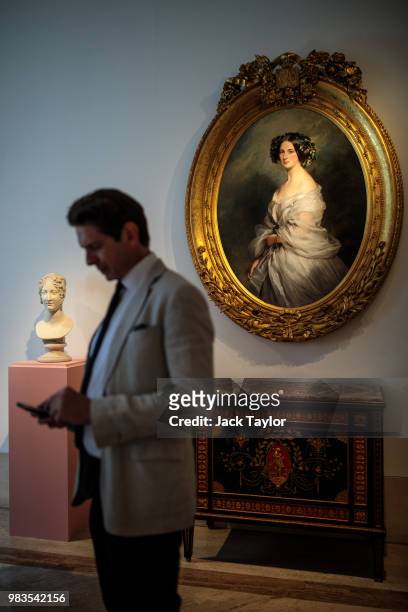 Gallery worker checks his phone in front of a 'Bust of Caroline Murat nee Bonaparte' by Antonio Canova and 'A Portrait of A Lady, Therese Freifrau...