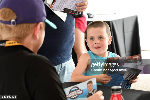 Young fan collects hero cards during the Driver Autograph session before the start of the NASCAR Camping World Truck Series Villa Lighting delivers...