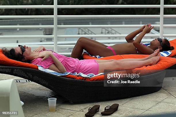 Donna Murphy and April Kim, on vacation from New York, relax next to the pool at The Strand, Ocean Drive Hotel on April 9, 2010 in Miami Beach,...