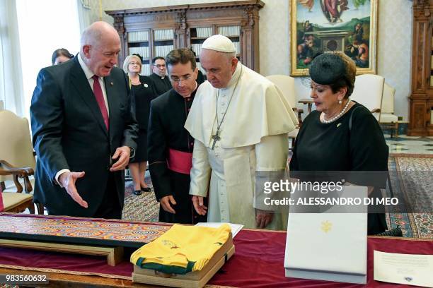 Pope Francis exchanges gifts with Australian Governor General Peter Cosgrove and his wife Lynne Cosgrove during a private audience at The Vatican on...