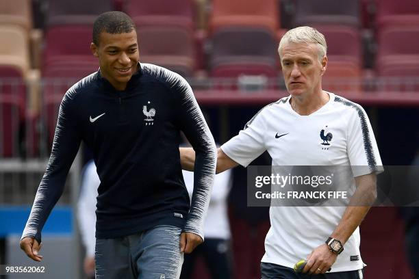 France's forward Kylian Mbappe speaks with France's coach Didier Deschamps as they take part in a training session of France national football team...