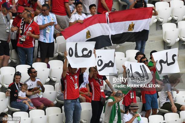 Egypt supporters carry a placard which reads in Arabic "We are with you, in the good times and the bad" ahead of the Russia 2018 World Cup Group A...