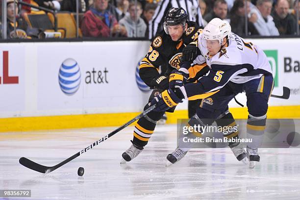 Toni Lydman of the Buffalo Sabres skates after the puck against Mark Recchi of the Boston Bruins at the TD Garden on April 8, 2010 in Boston,...