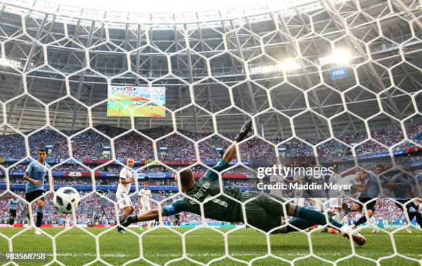 Luis Suarez of Uruguay scores past Igor Akinfeev of Russia his team's first goal during the 2018 FIFA World Cup Russia group A match between Uruguay...