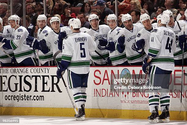 Christian Ehrhoff of the Vancouver Canucks high fives his teammates after assisting teammate Michael Grabner in his hat trick in the second period...