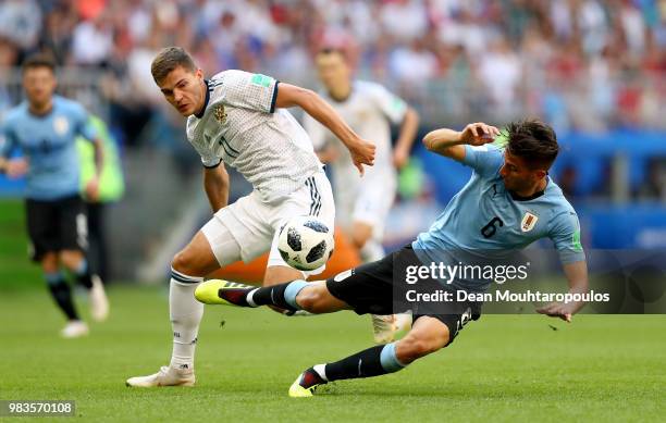 Rodrigo Bentancur of Uruguay is tackled by Roman Zobnin of Russia during the 2018 FIFA World Cup Russia group A match between Uruguay and Russia at...