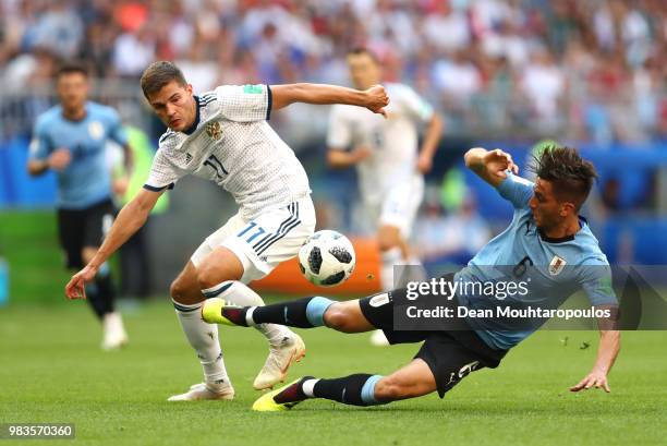 Rodrigo Bentancur of Uruguay is tackled by Roman Zobnin of Russia during the 2018 FIFA World Cup Russia group A match between Uruguay and Russia at...
