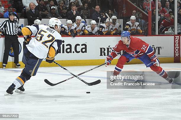 Craig Rivet of Buffalo Sabres skates with the puck in front of Travis Moen of Montreal Canadiens during the NHL game on April 3, 2010 at the Bell...