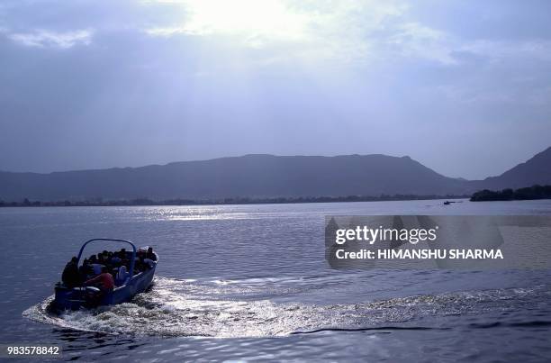 Indian tourists ride a speedboat at Ana Sagar Lake in Ajmer, in the Indian state of Rajasthan, on June 25, 2018.