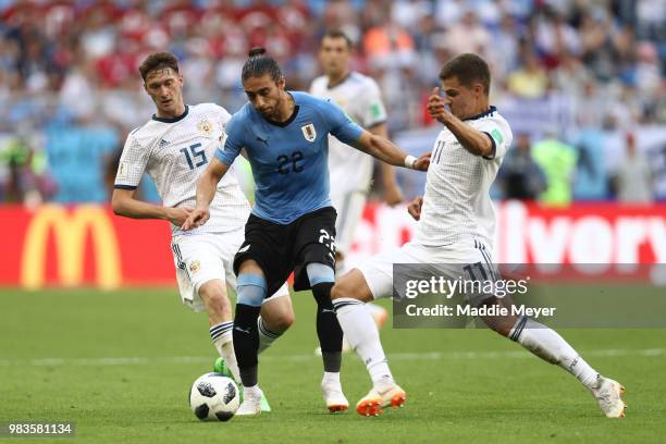 Martin Caceres of Uruguay challenge for the ball with Roman Zobnin and Alexey Miranchuk of Russia during the 2018 FIFA World Cup Russia group A match...