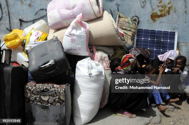 Displaced family who fled the war in Yemen’s port city of Hodeida sit on the ground as they wait to register their names at a displacement center on...