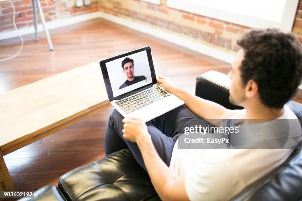 colleagues video conferencing with a laptop - presents easy a foto e immagini stock