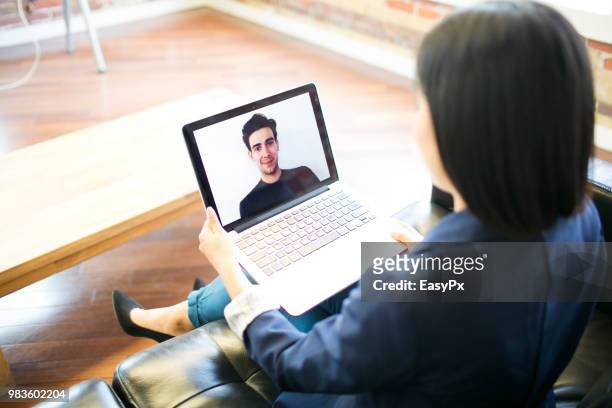 colleagues video conferencing with a laptop - presents easy a stock pictures, royalty-free photos & images