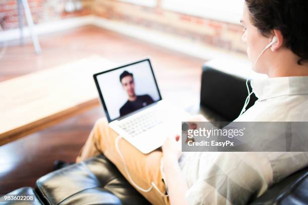 colleagues video conferencing with a laptop - presents easy a foto e immagini stock