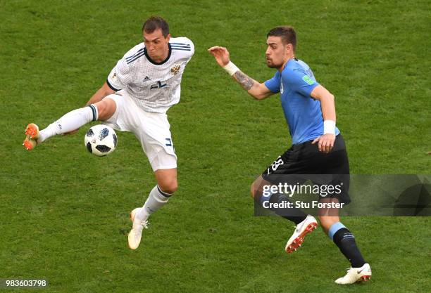 Artem Dzyuba of Russia is challenged by Sebastian Coates of Uruguay during the 2018 FIFA World Cup Russia group A match between Uruguay and Russia at...