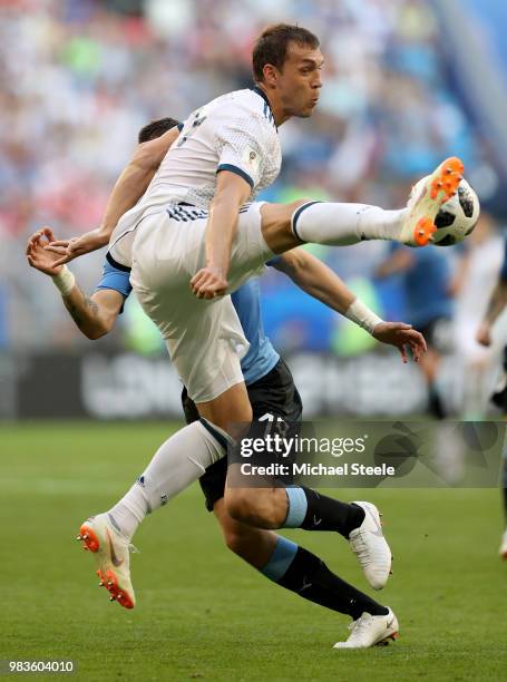 Artem Dzyuba of Russia controls he ball under pressure from Sebastian Coates of Uruguay during the 2018 FIFA World Cup Russia group A match between...